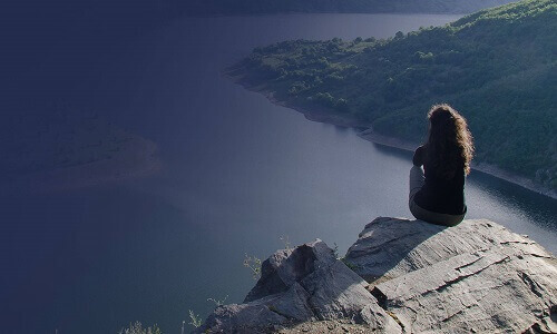 Woman sitting on the edge of a cliff