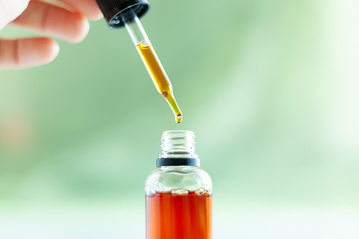 Broad spectrum CBD oil-hand holding CBD oil dropper