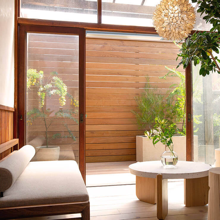 Couch and table in front of minimalistic window and wood panels