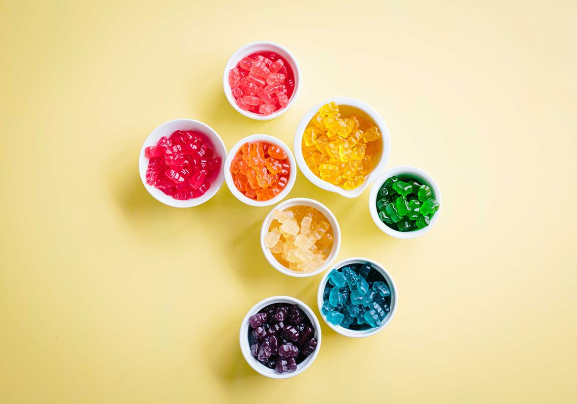 colourful CBD gummies on yellow background