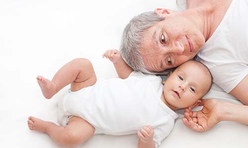 Baby and mother laying on a bed
