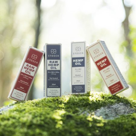Endoca Hemp Oil and Raw Hemp Oil product boxes arranged on green forest moss