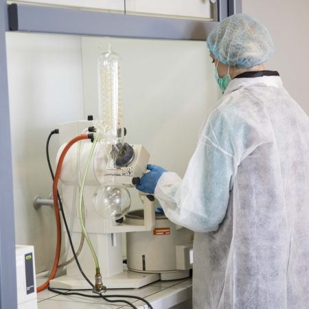 Lab technician operating CBD extraction and distillation equipment in the Endoca laboratory