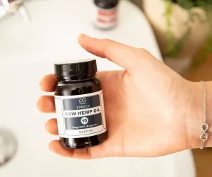Hand holding a jar of Endoca RAW Hemp Oil CBD capsules