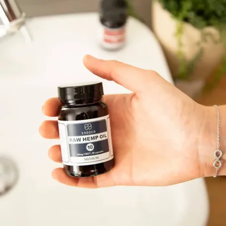 Hand holding a jar of Endoca RAW Hemp Oil CBD capsules